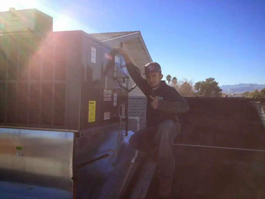 HVAC technician performing AC Tune-Up on a rooftop unit in Lake Barcroft